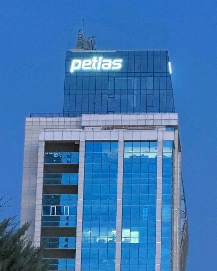 Bina cephesinde Petlas yazılı, ayrı harflerden oluşan ışıklı tabela.